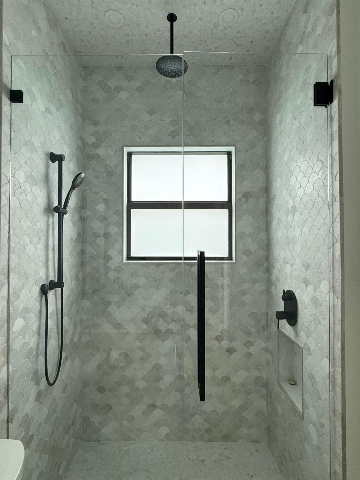 Walk-in marble shower with matte black fixtures
