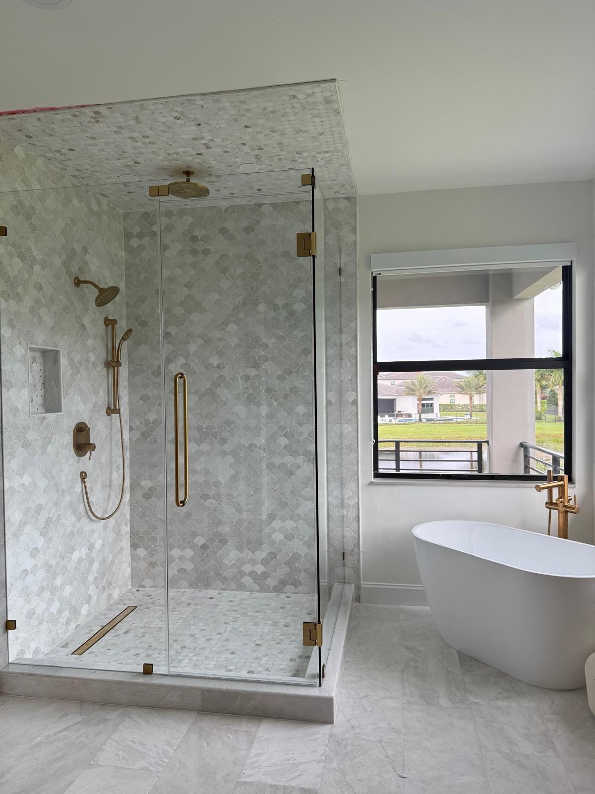 Finished marble bathroom with a glass shower and freestanding tub